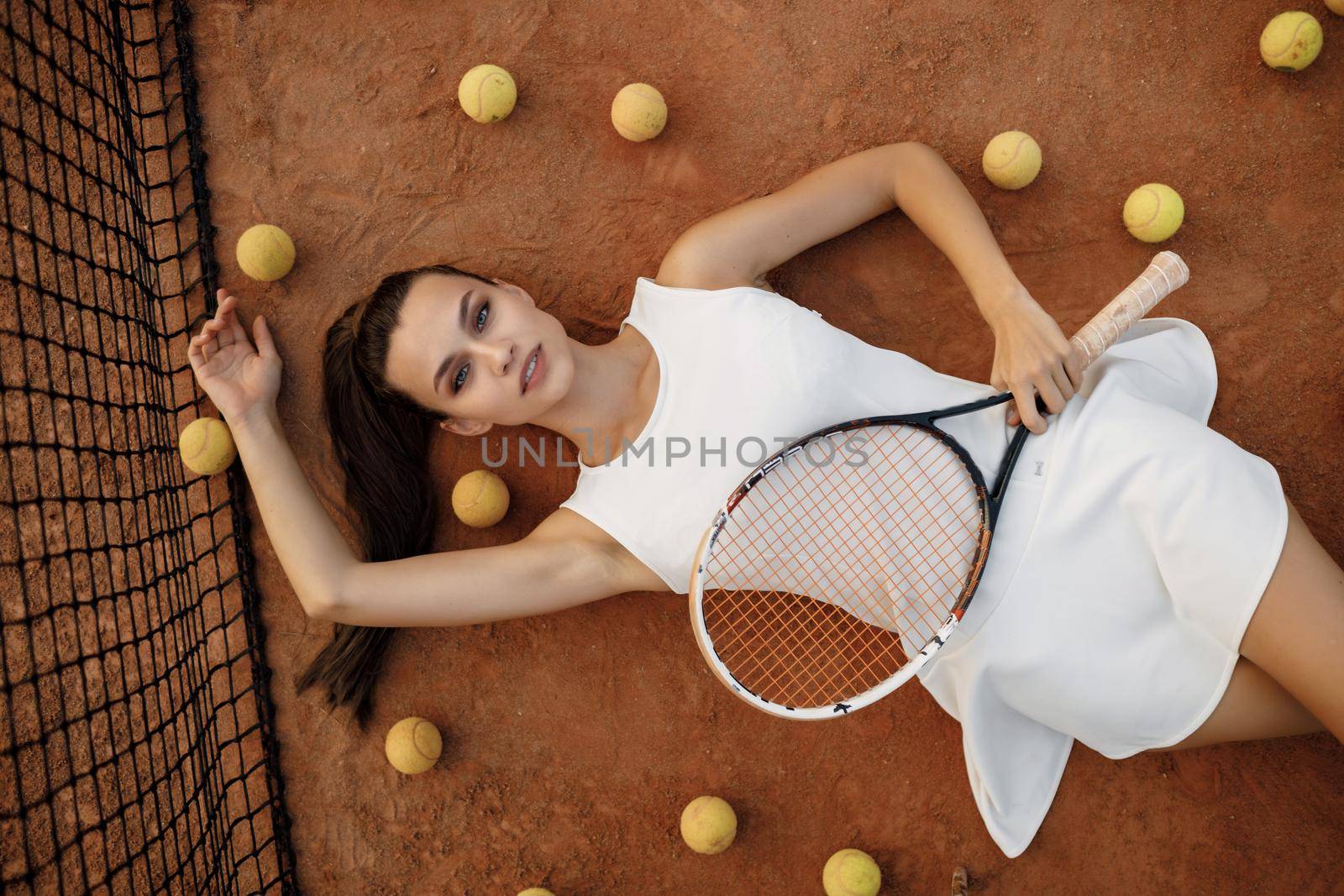 Young woman tennis player with racket. fashion portrait by splash