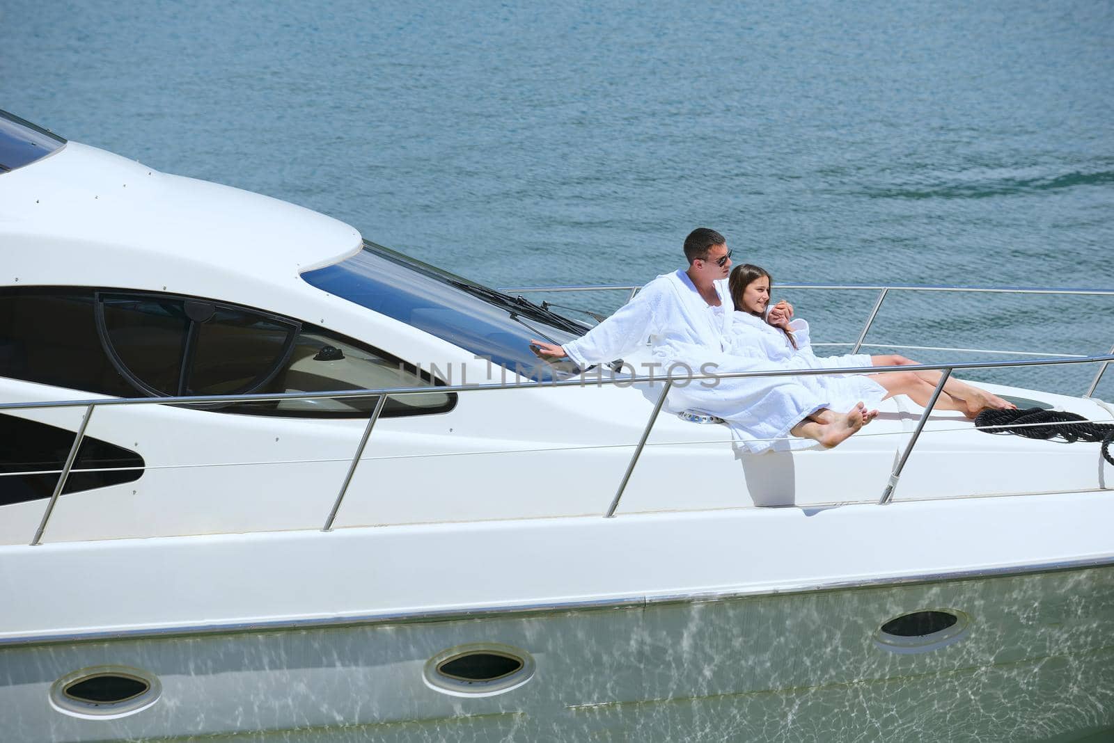 Romantic young couple spending time together and relaxing on yacht