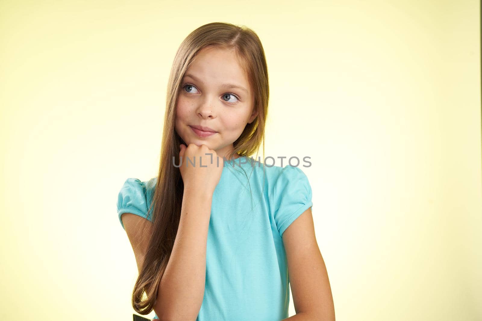 cheerful little girl with long hair close-up studio posing. High quality photo