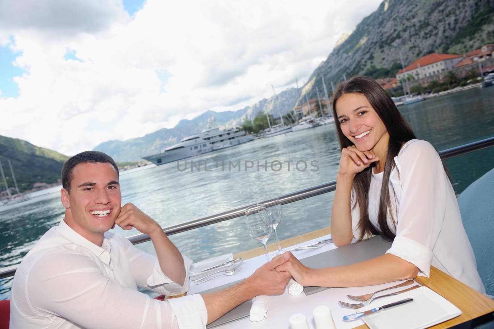 happy young couple having lanch at beautiful restaurant on the beach