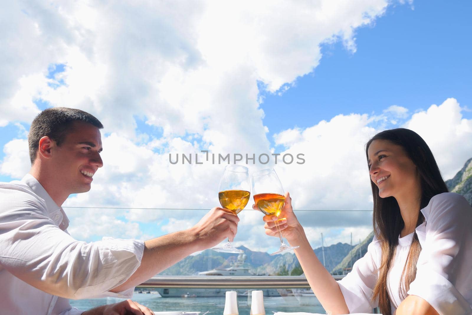 happy young couple having lanch at beautiful restaurant on the beach