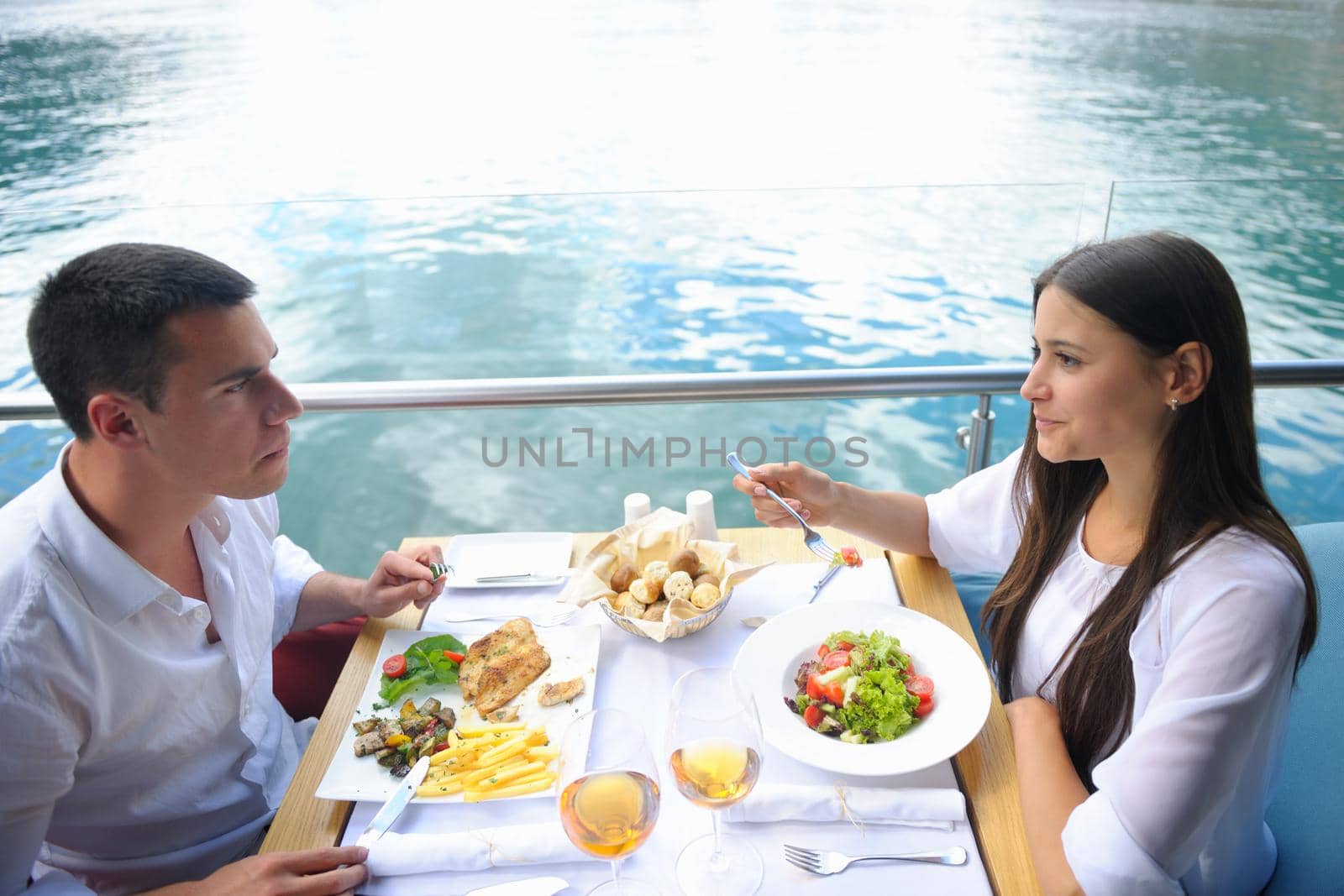 happy young couple having lanch at beautiful restaurant on the beach