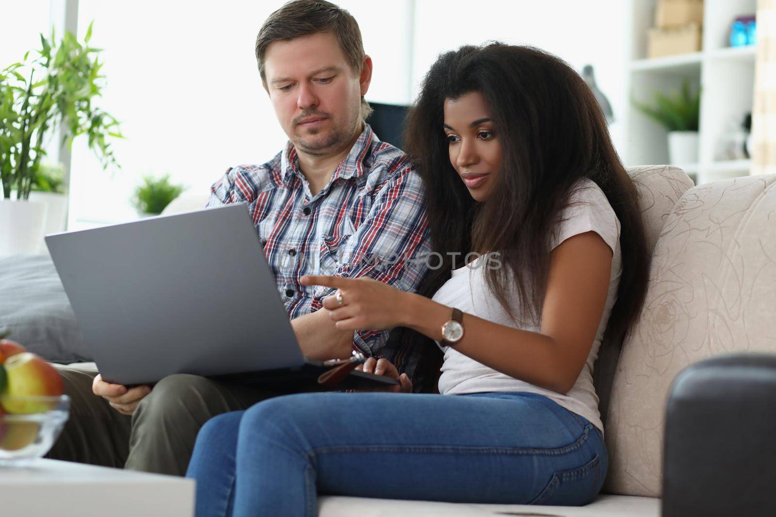 Middle aged man and latino american woman choosing something online by kuprevich