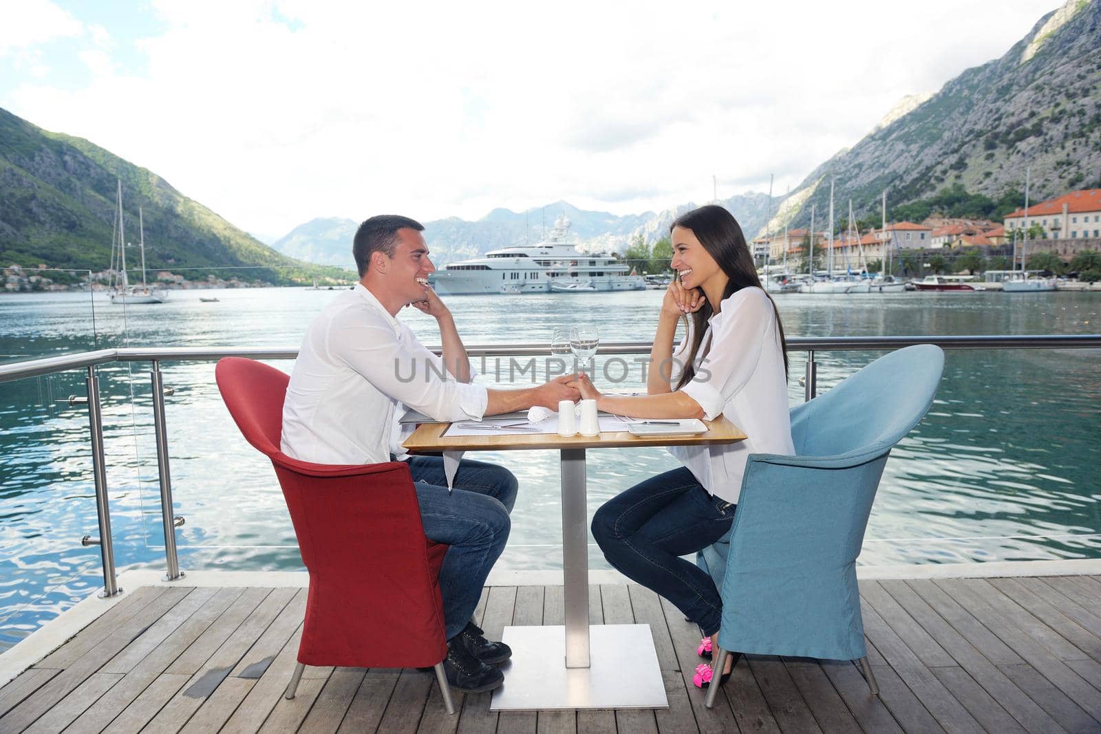 happy young couple having lanch at beautiful restaurant on by the sea on  beach