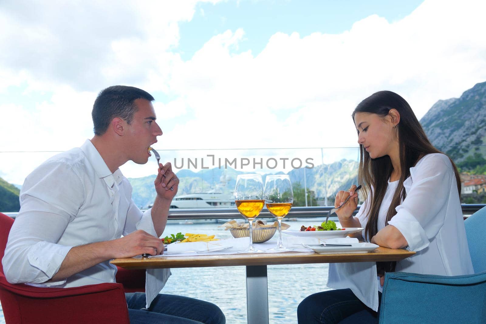 happy young couple having lanch at beautiful restaurant on the beach