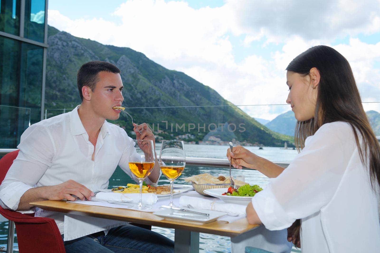 happy young couple having lanch at beautiful restaurant on the beach