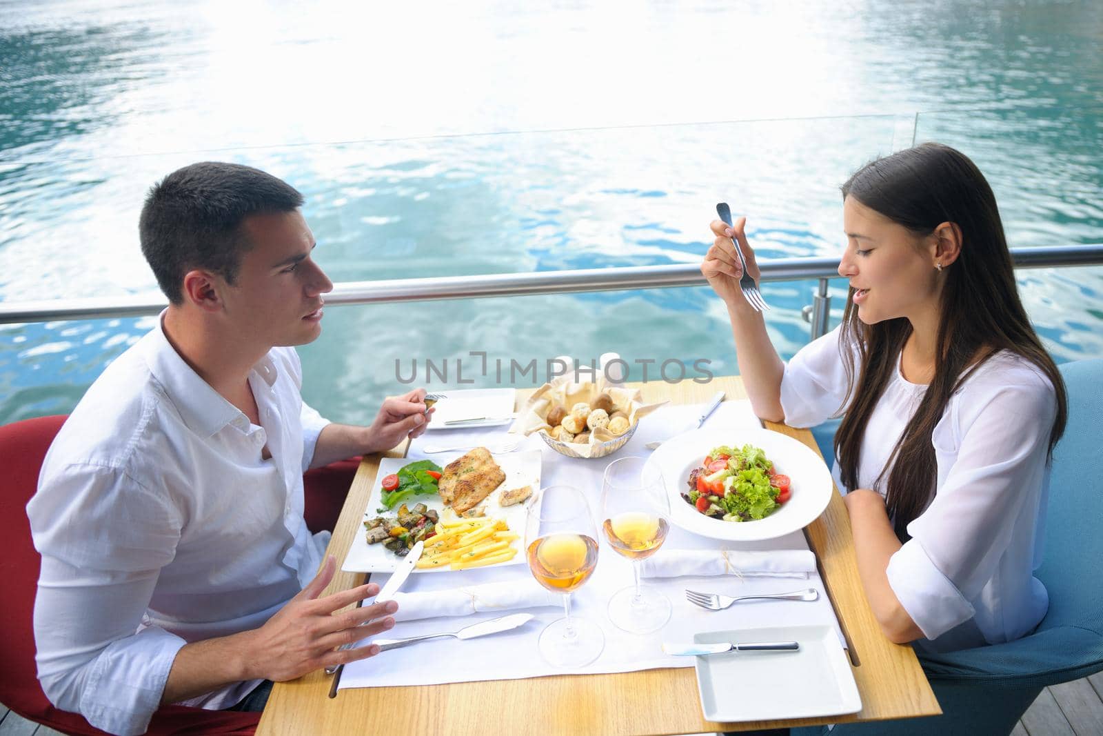 happy young couple having lanch at beautiful restaurant on the beach