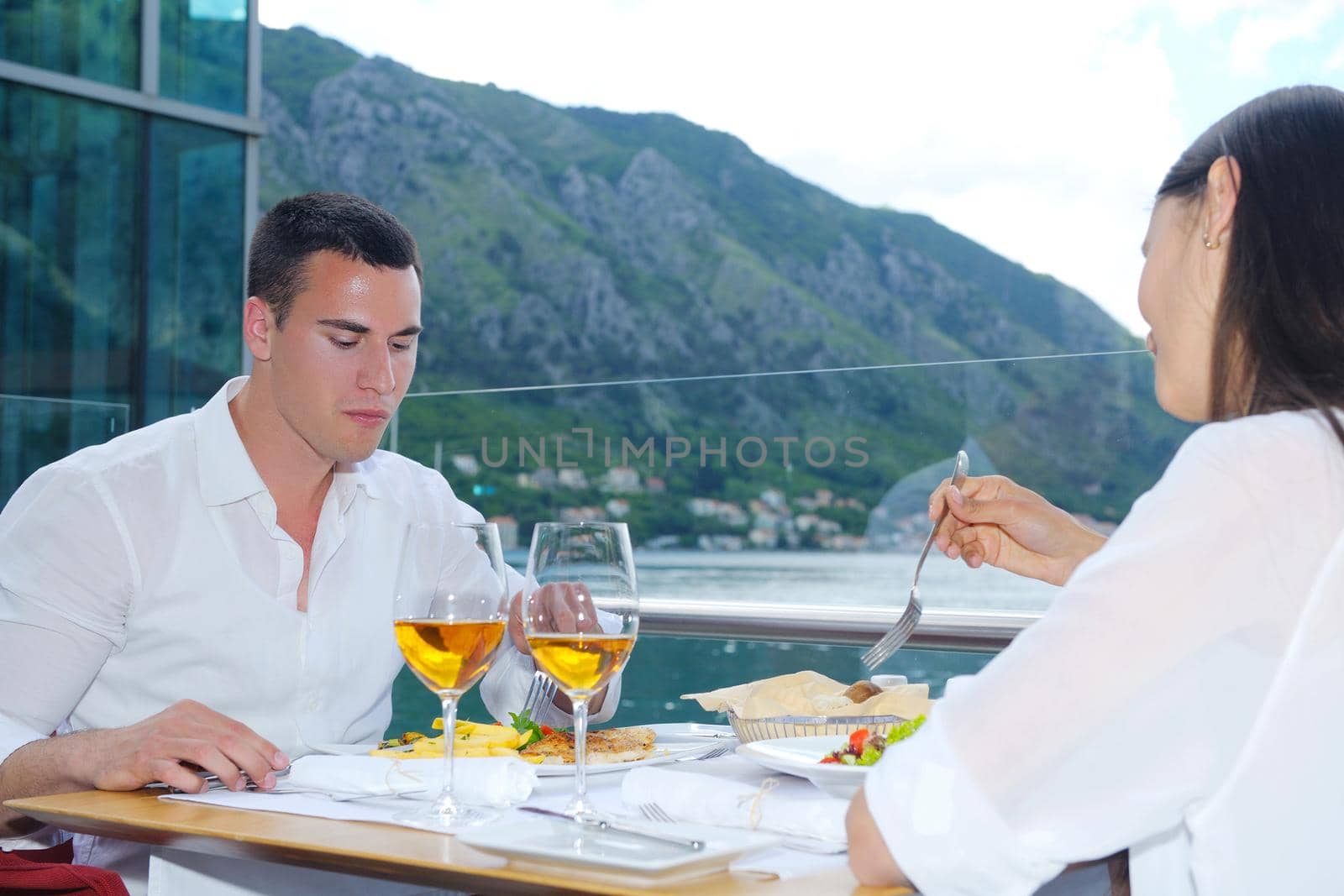 happy young couple having lanch at beautiful restaurant on by the sea on  beach