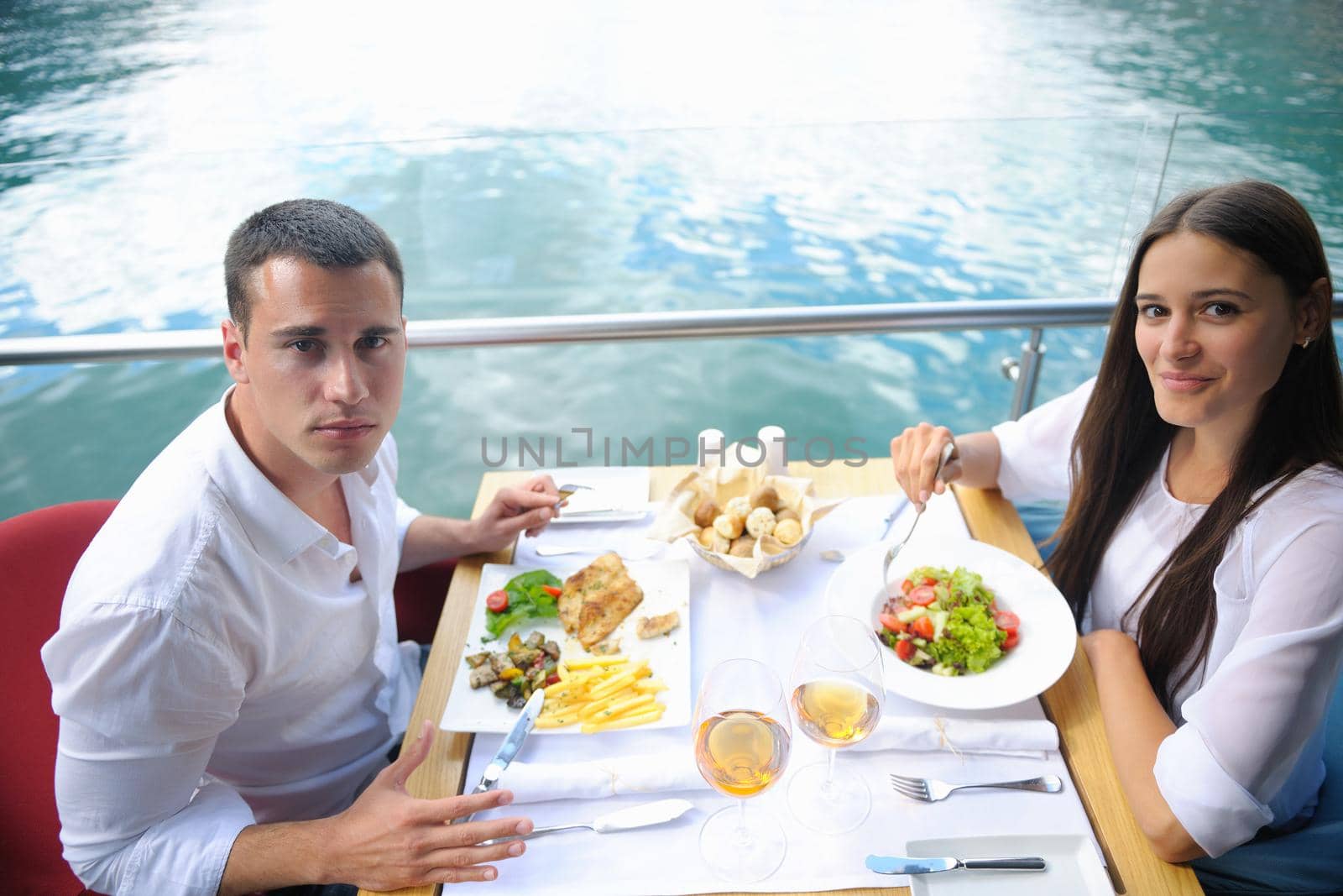 happy young couple having lanch at beautiful restaurant on by the sea on  beach