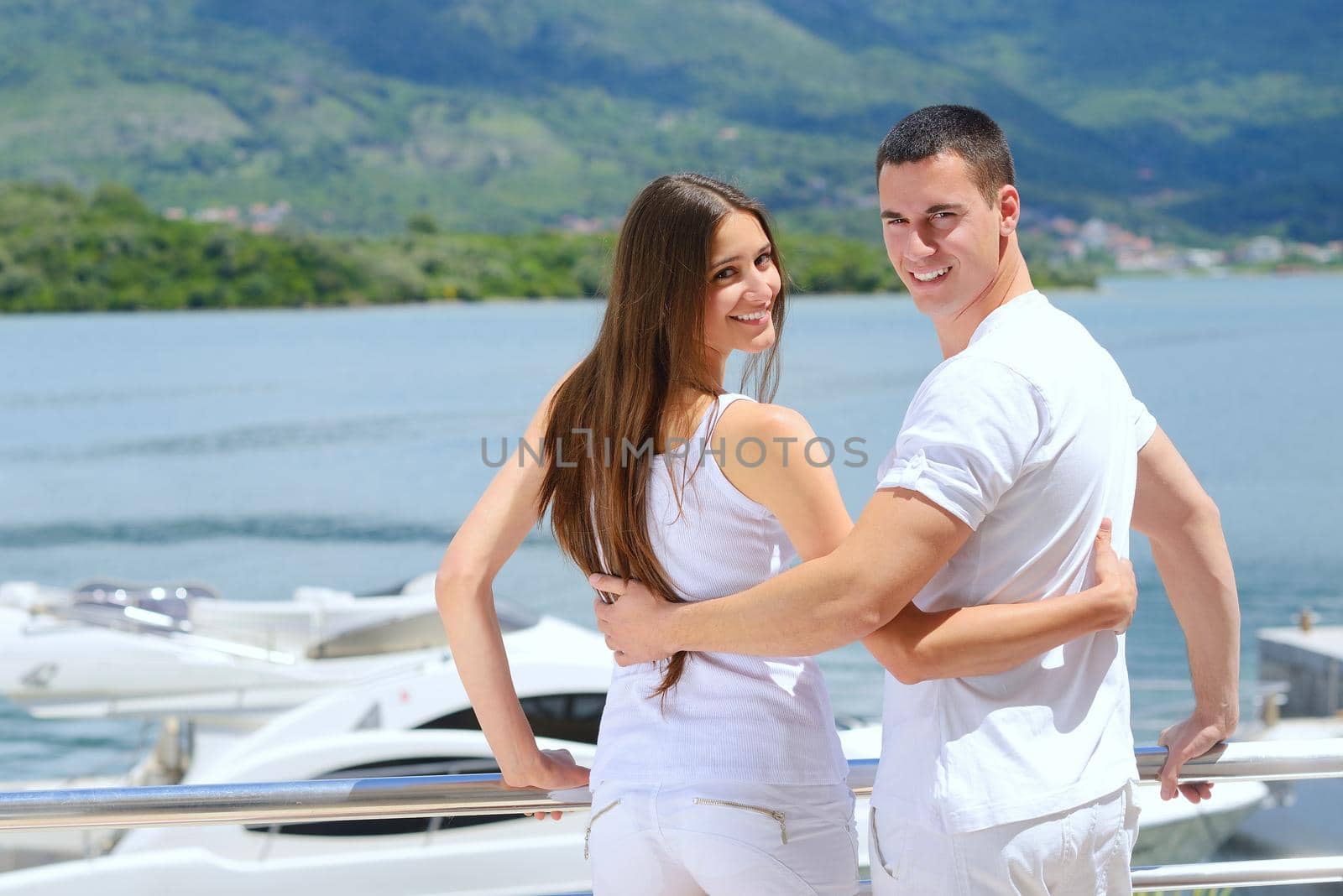 Romantic young couple spending time together and relaxing on yacht