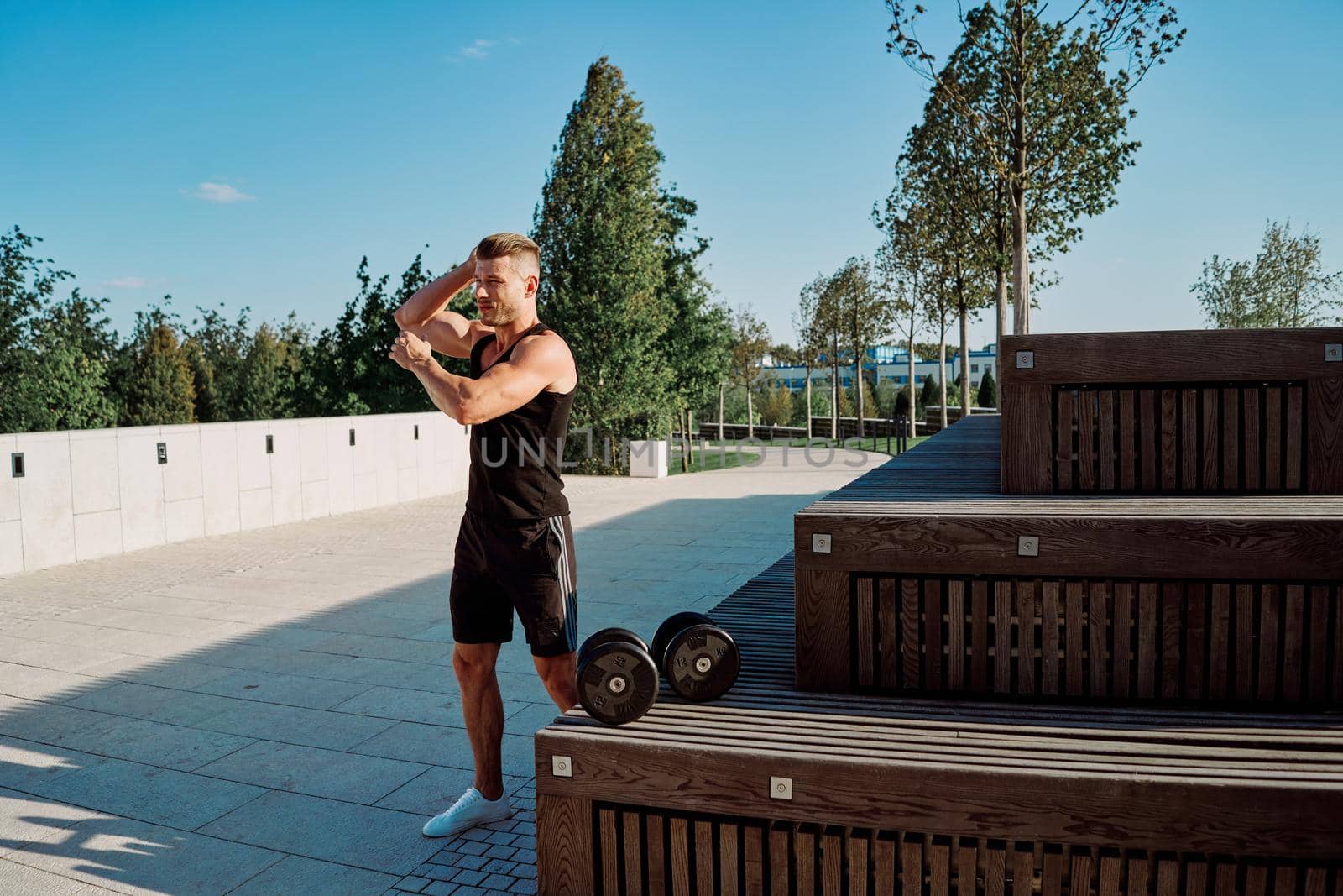 sporty man in the park with dumbbells workout fitness. High quality photo