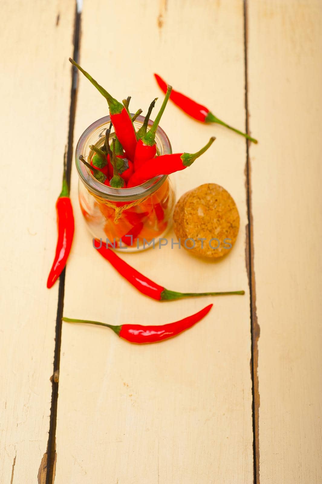 red chili peppers on a glass jar by keko64