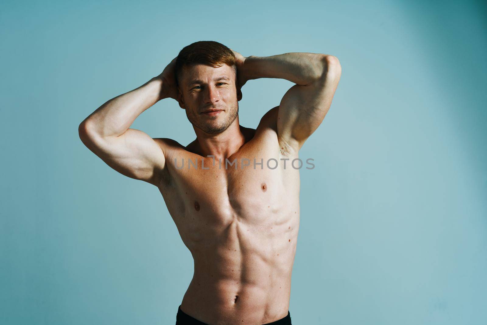 bodybuilder with muscular body posing press blue background by Vichizh