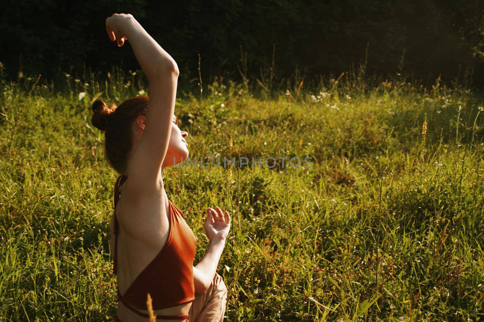 woman in summer sitting on the grass outdoors meditation freedom. High quality photo