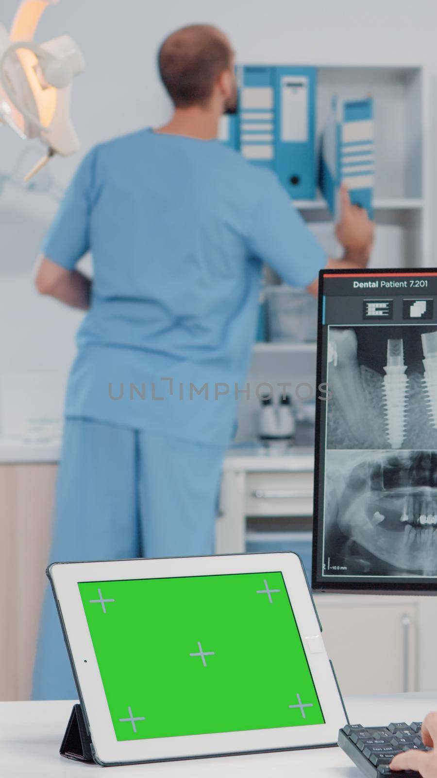 Orthodontist using horizontal green screen on tablet for oral care and dentistry. Woman working as dentist with chroma key and isolated mockup template while looking at teeth scan