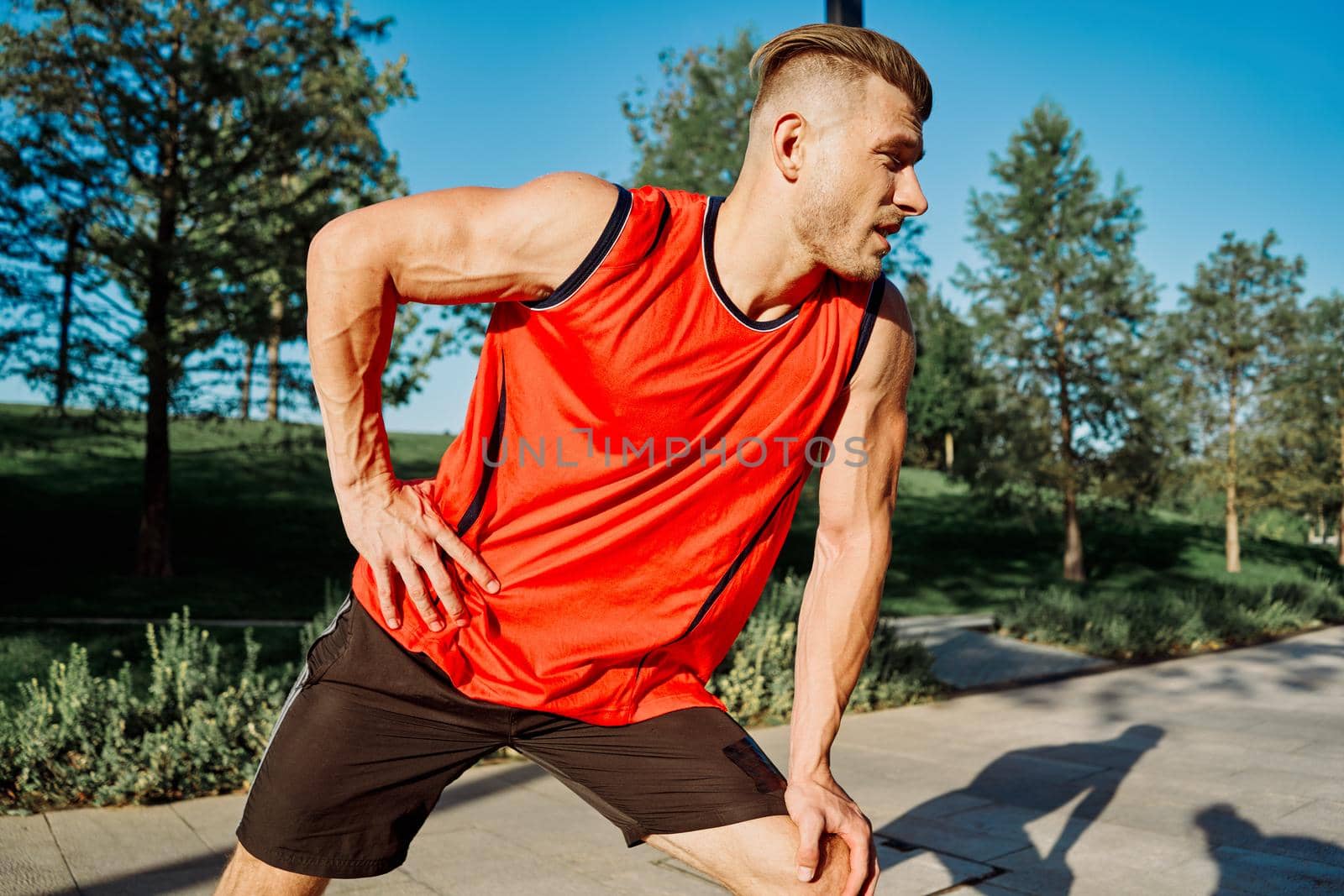 sporty man workout dumbbells exercise outdoors in the park by Vichizh