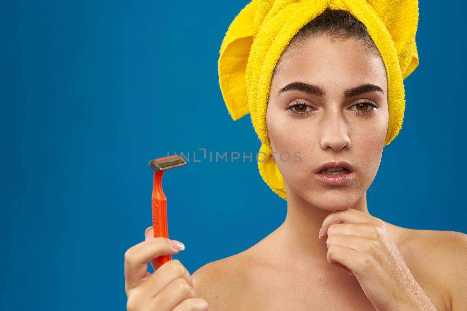 cheerful woman with a yellow towel on his head shaving by Vichizh