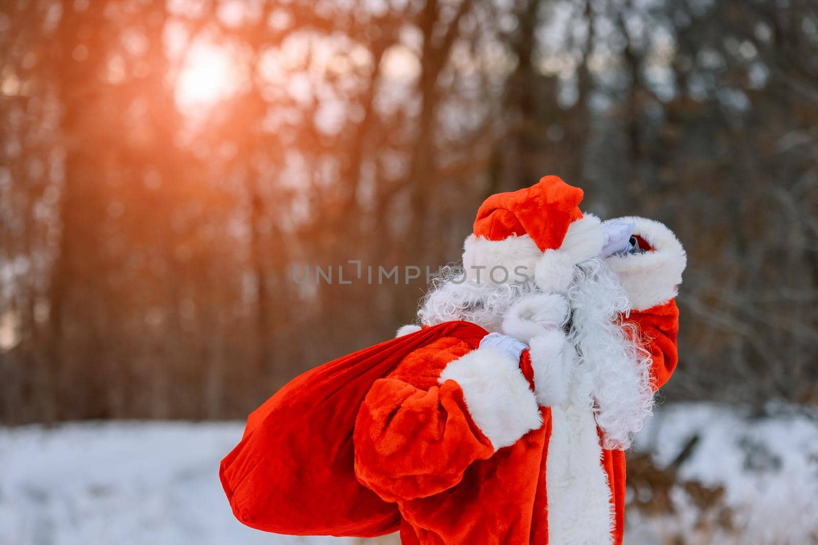 Magnificent snow covered landscape Santa Claus carrying Merry Christmas present gifts by ungvar