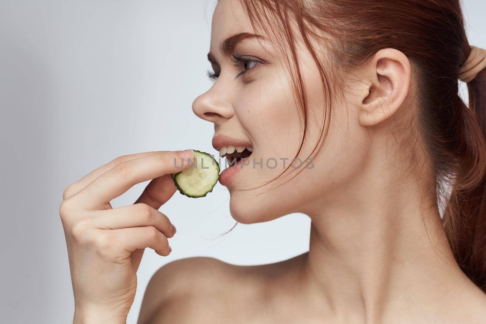 attractive woman with bare shoulders cucumber skin care health. High quality photo