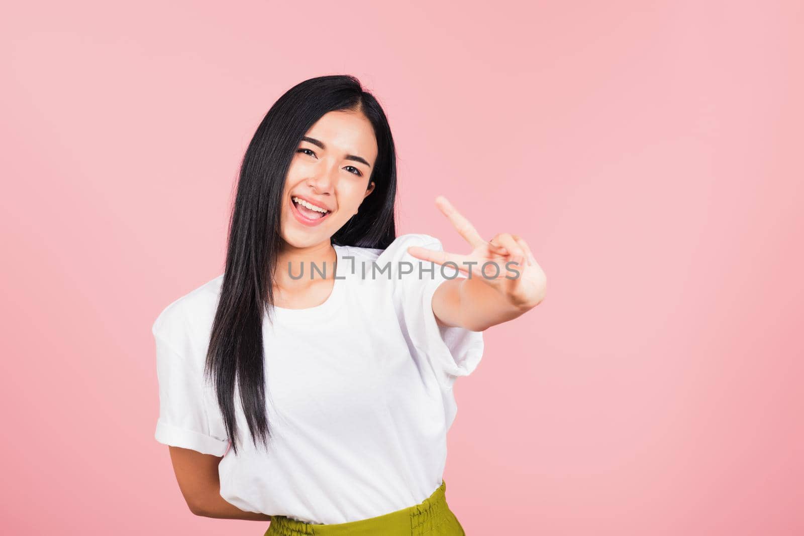 woman teen smile standing showing finger making v-sign victory symbol by Sorapop
