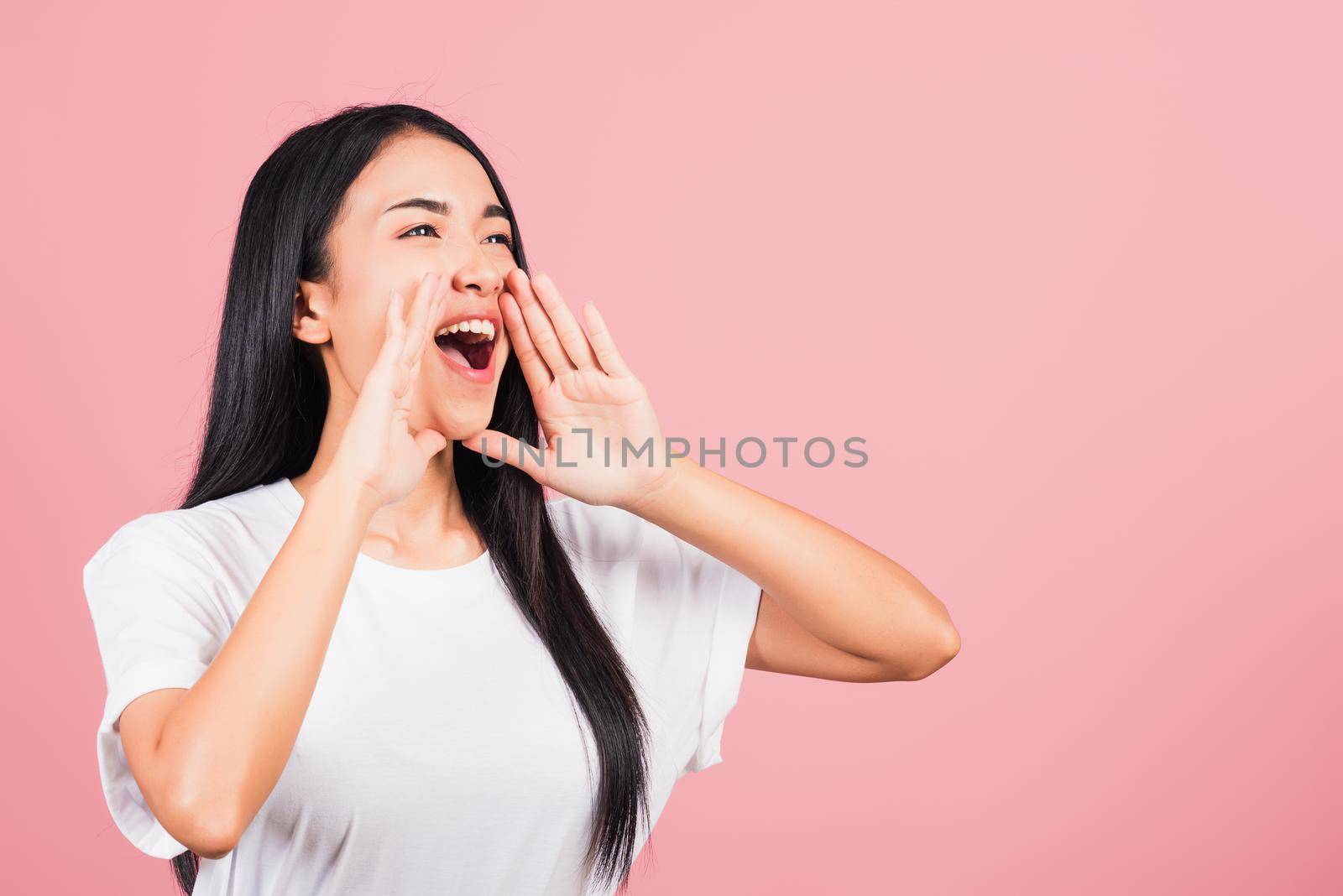 Asian happy portrait beautiful cute young woman teen standing hand on mouth talking news announcement studio shot isolated on pink background, Thai female looking to side away with copy space