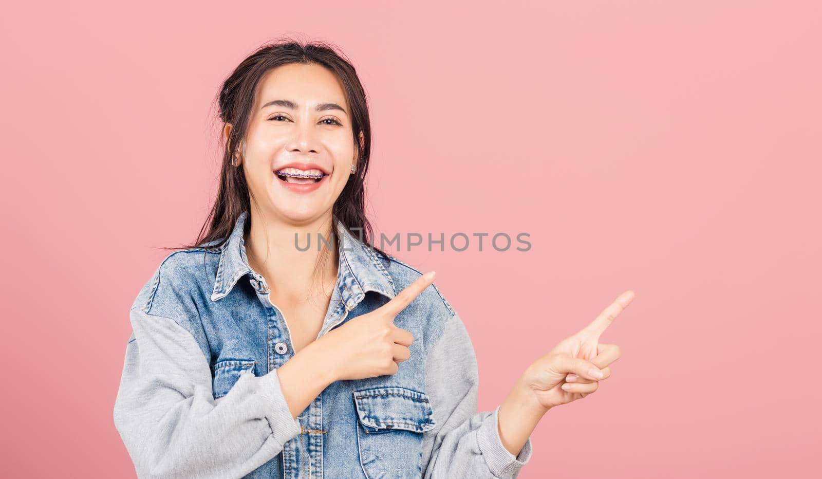 woman wear denim standing pointing finger side away by Sorapop