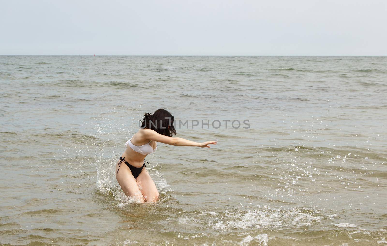 young brunette woman swiming in the sea on sunny summer day