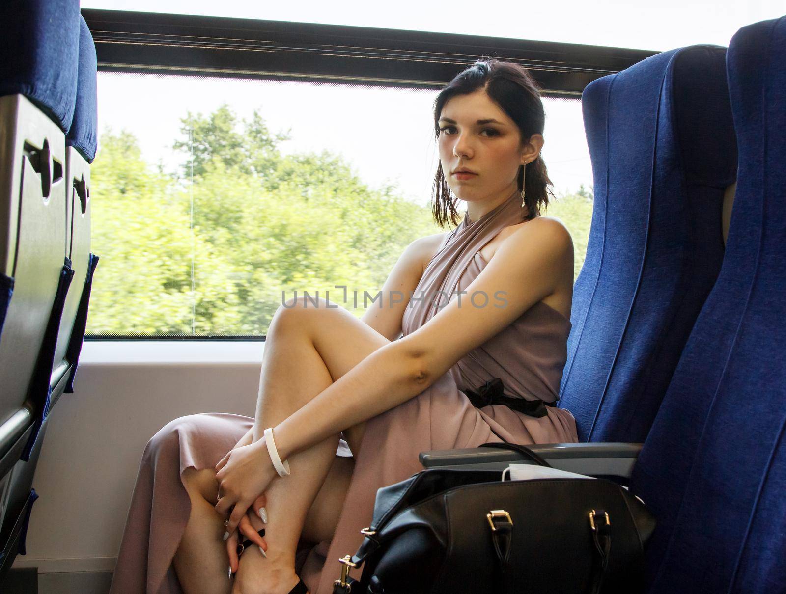 young woman sitting by the window in the train by raddnatt