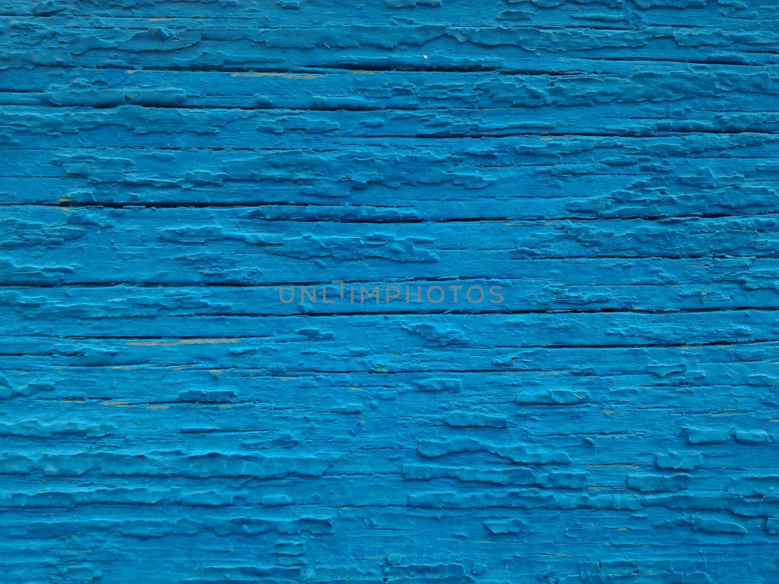 Texture of old paint on the wooden surface. Background of cracked blue paint, close-up