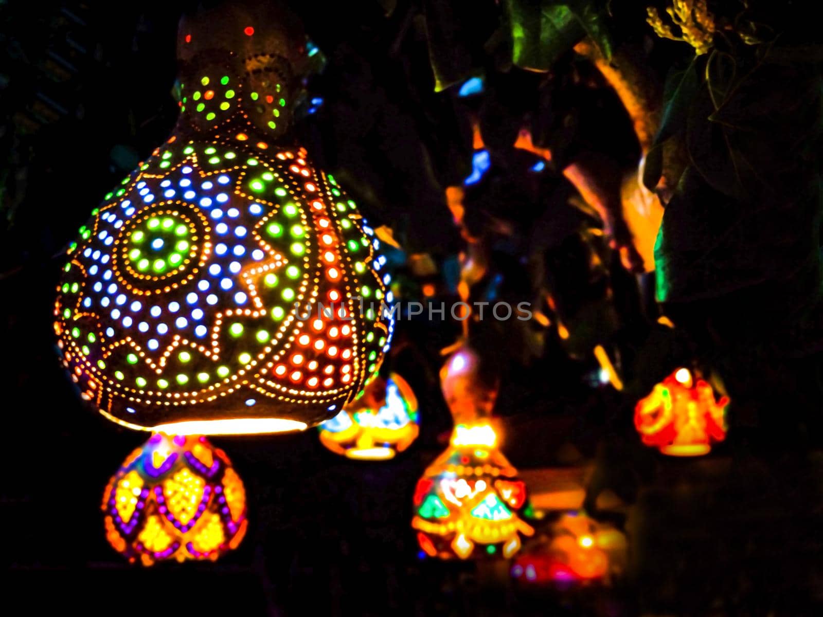 Oriental lanterns glow with multicolored lights in the dark by Laguna781