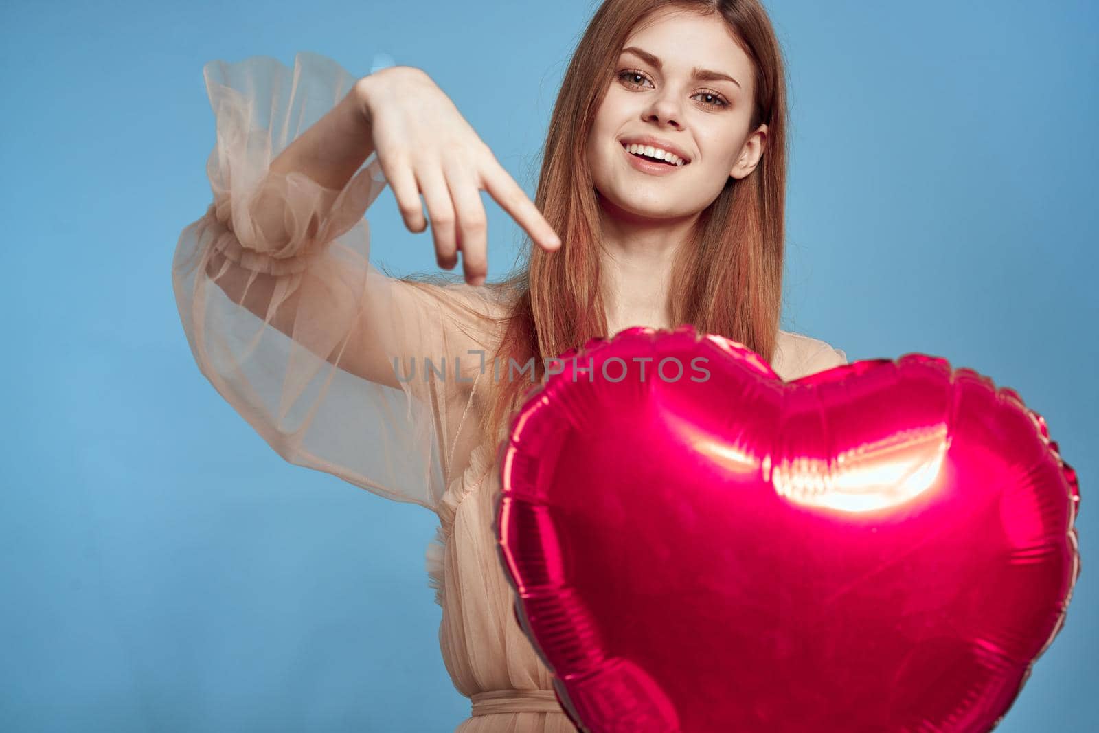 cheerful woman Birthday party gift heart balloon blue background. High quality photo