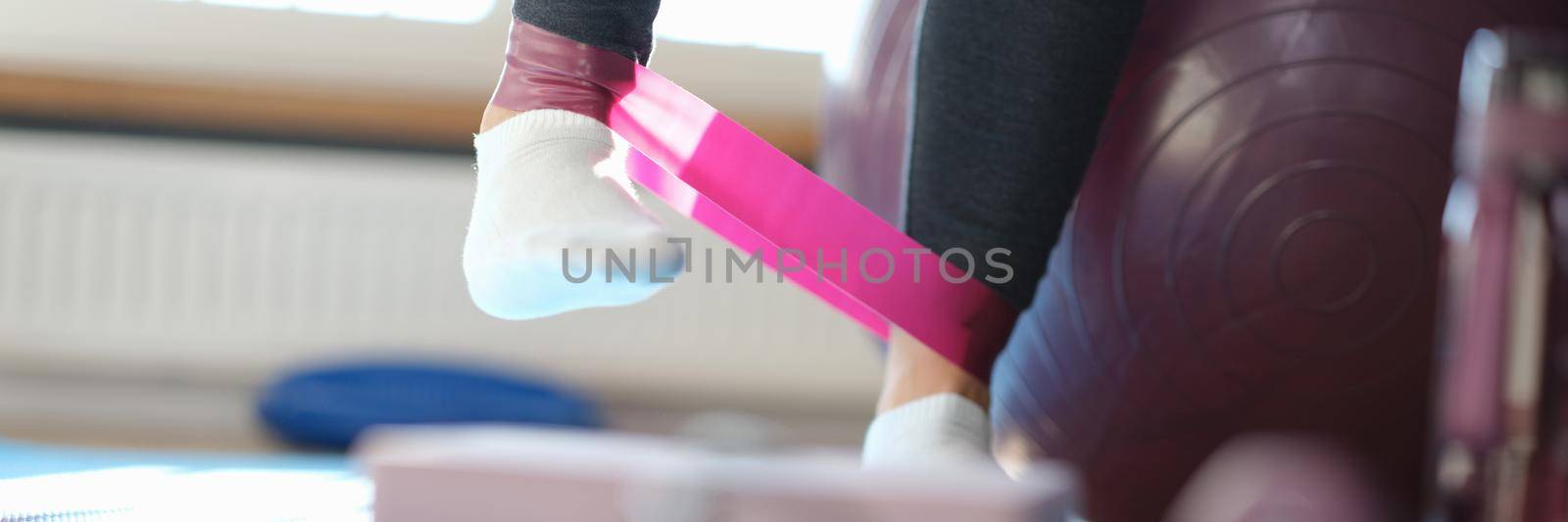 Sports exercises with an elastic band for legs at home closeup by kuprevich