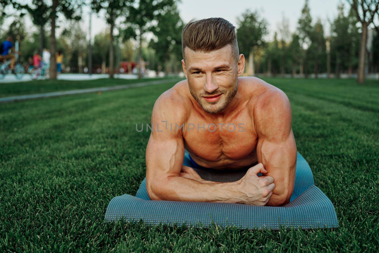 sports muscular man doing fitness crossfit in the park by Vichizh