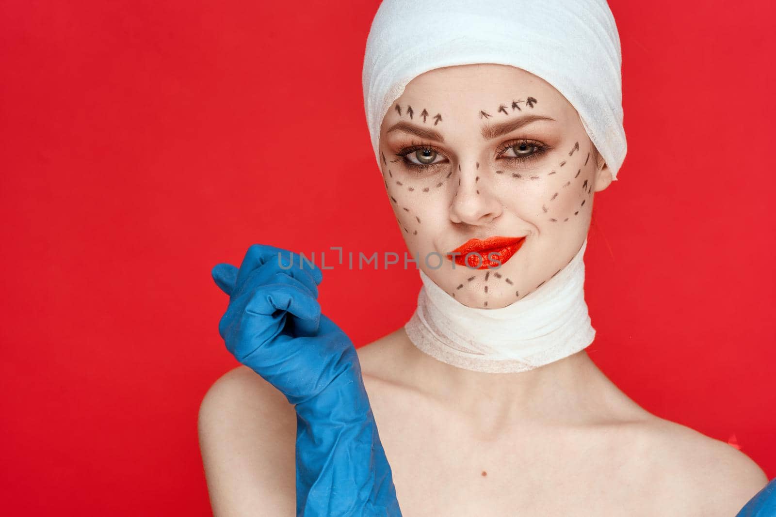 female patient posing in blue gloves red lips surgery facial rejuvenation isolated background. High quality photo