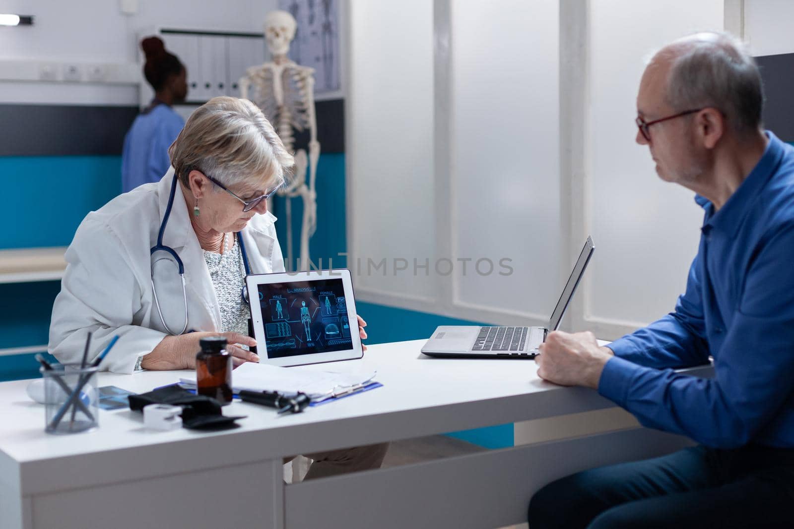 Medic and patient analyzing illustration of human body on digital tablet, to explain medical diagnosis. General practitioner and man looking at anatomical analysis on gadget for healthcare