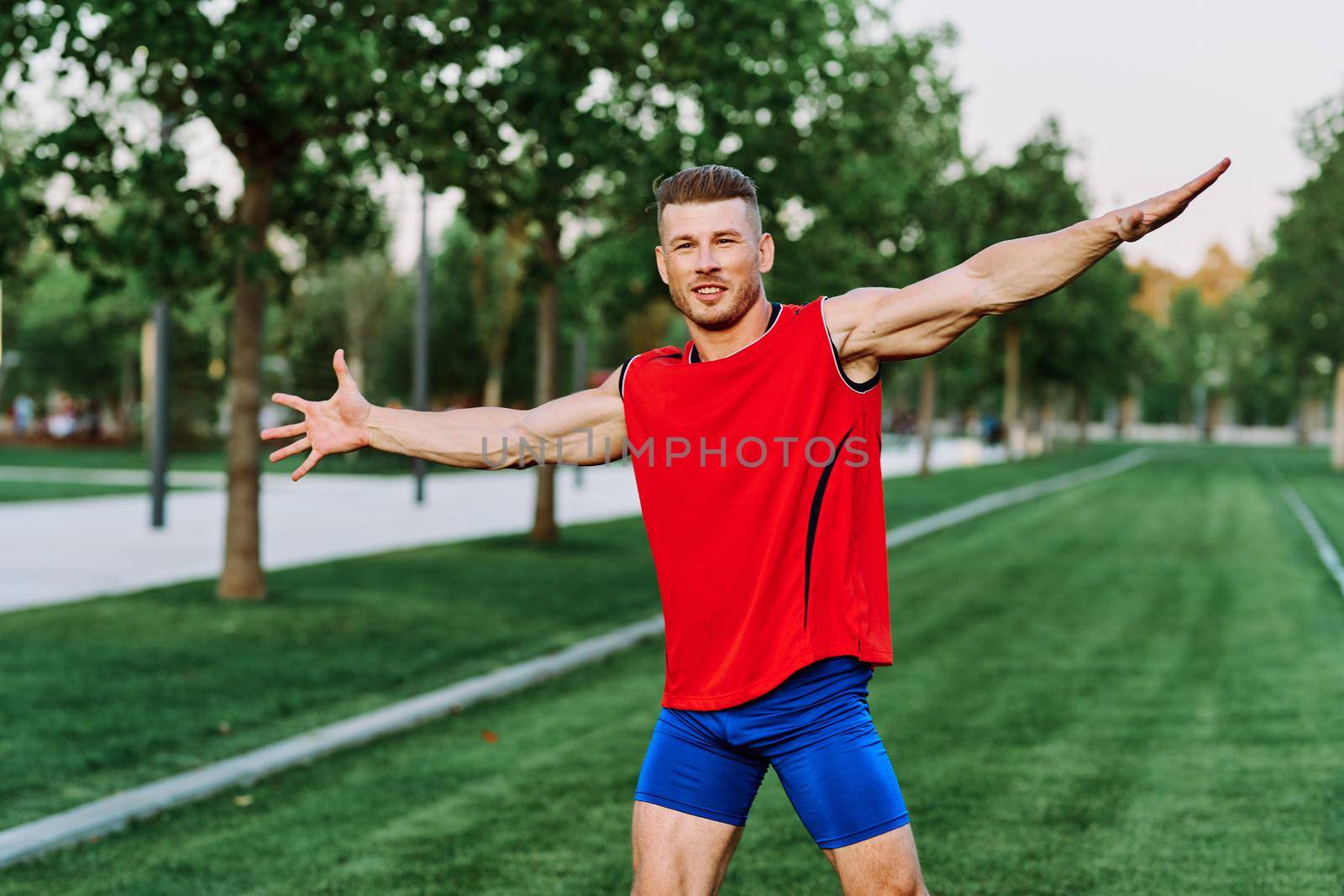 athletic man in red tank top posing outdoors fitness. High quality photo