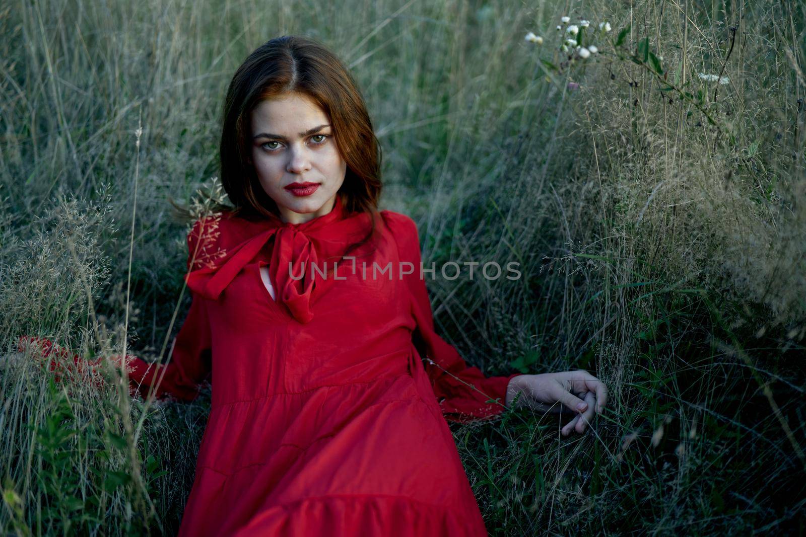 woman lies on the grass in a red dress landscape fashion by Vichizh