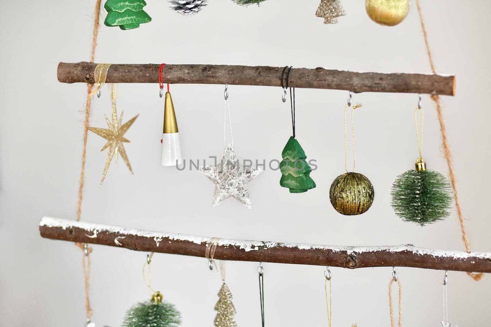 Handmade wooden Christmas tree with toys hanging on the wall