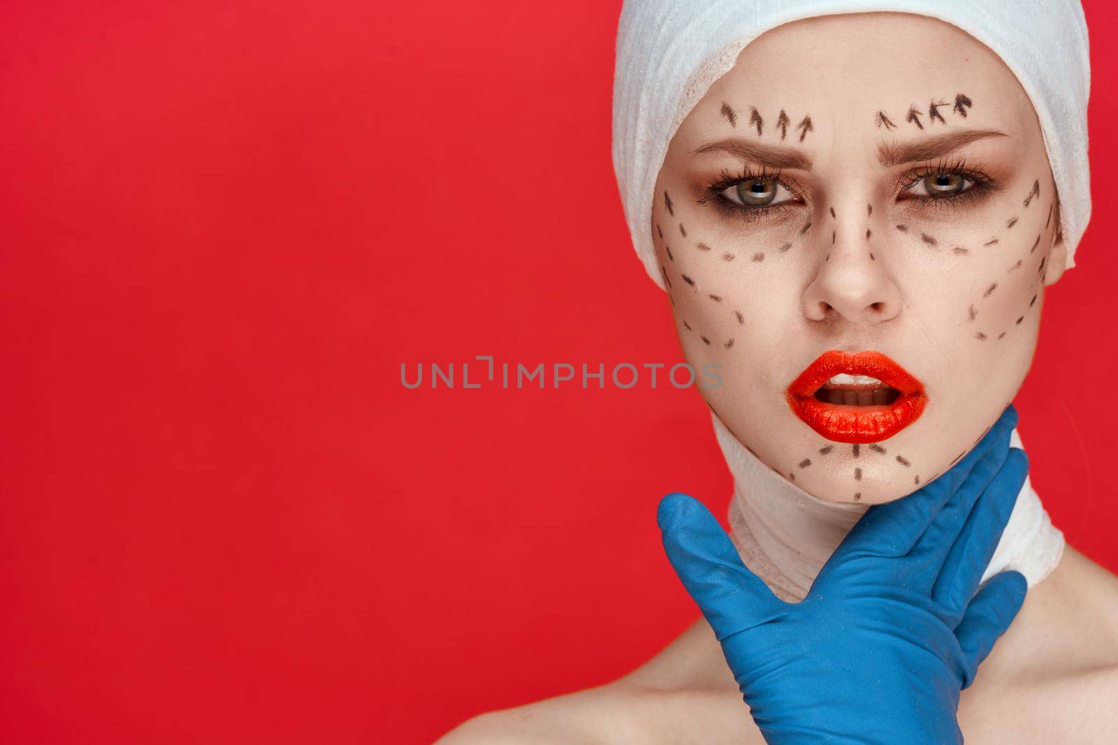 a person in blue gloves syringe in hands contour on the face lifting red background. High quality photo