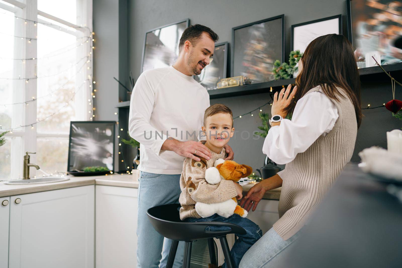 Happy young family spending time together in kitchen at home at Christmas holidays