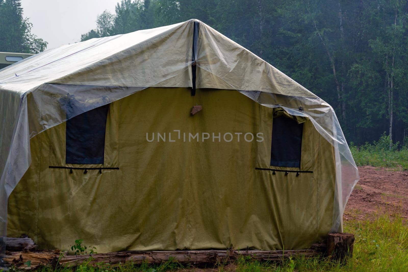 Military tent in the field. field camp in nature. large green tarpaulin tent. temporary field camp.