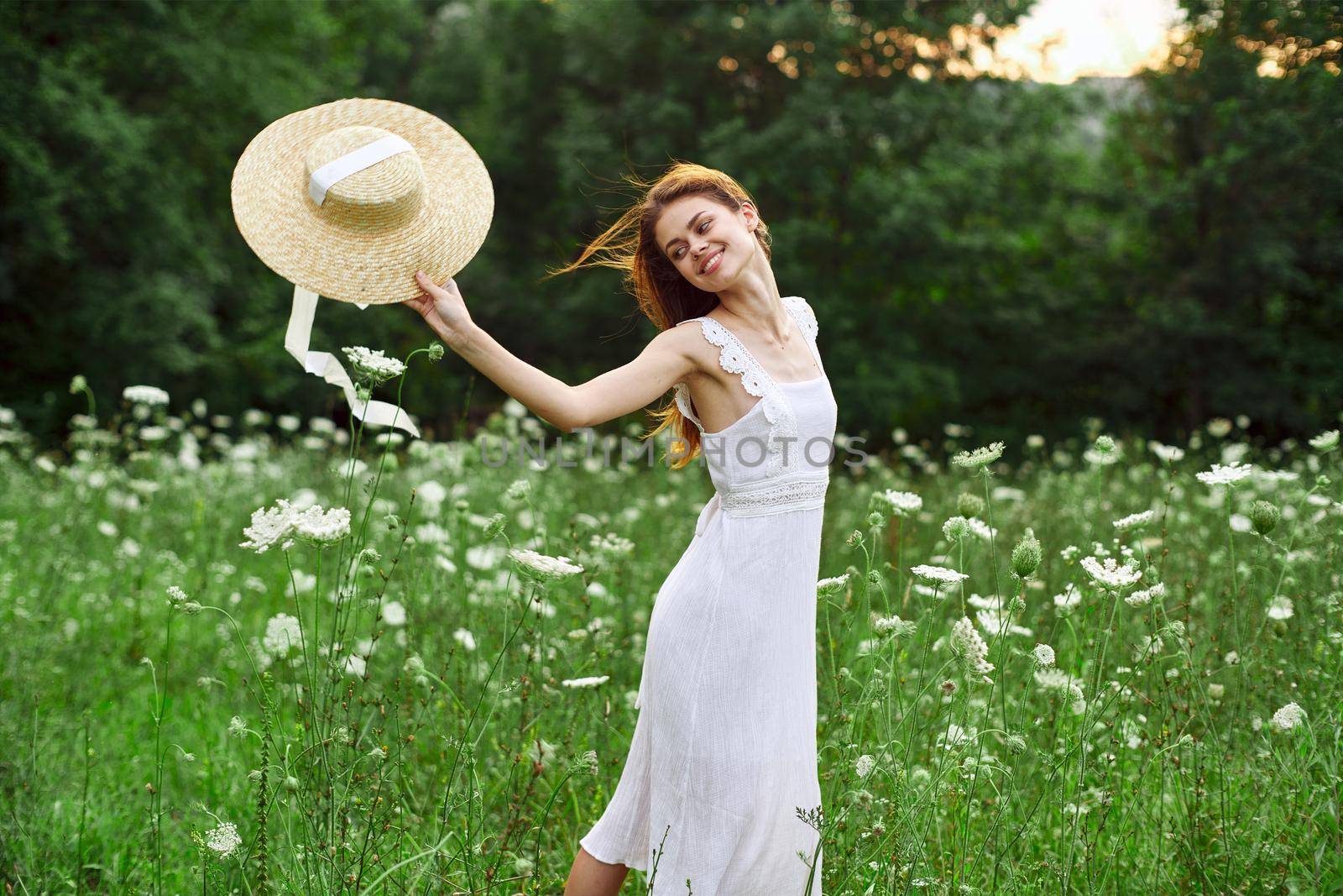 Woman in white dress hat holding flowers nature walk. High quality photo