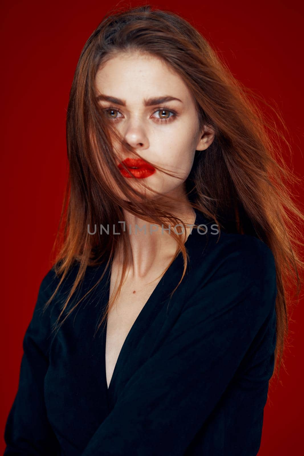 pretty woman with red lips red hair Glamor posing red background. High quality photo