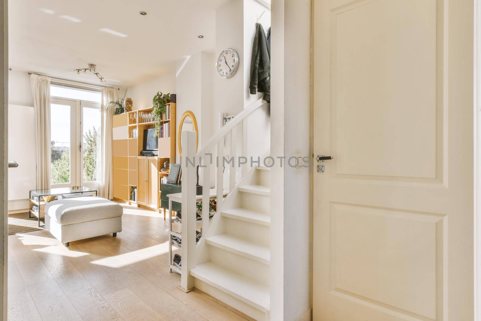 Luxurious corridor leading to the living room with a white wooden staircase