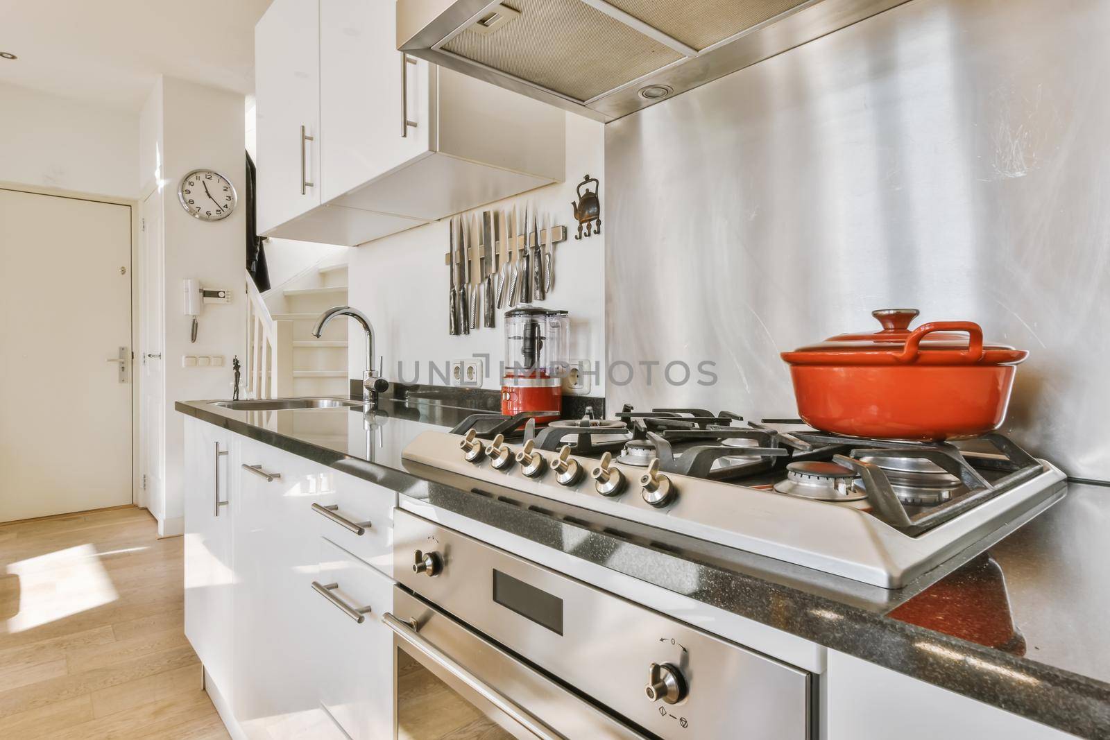 Luxurious kitchen with white cabinets and a bright red saucepan