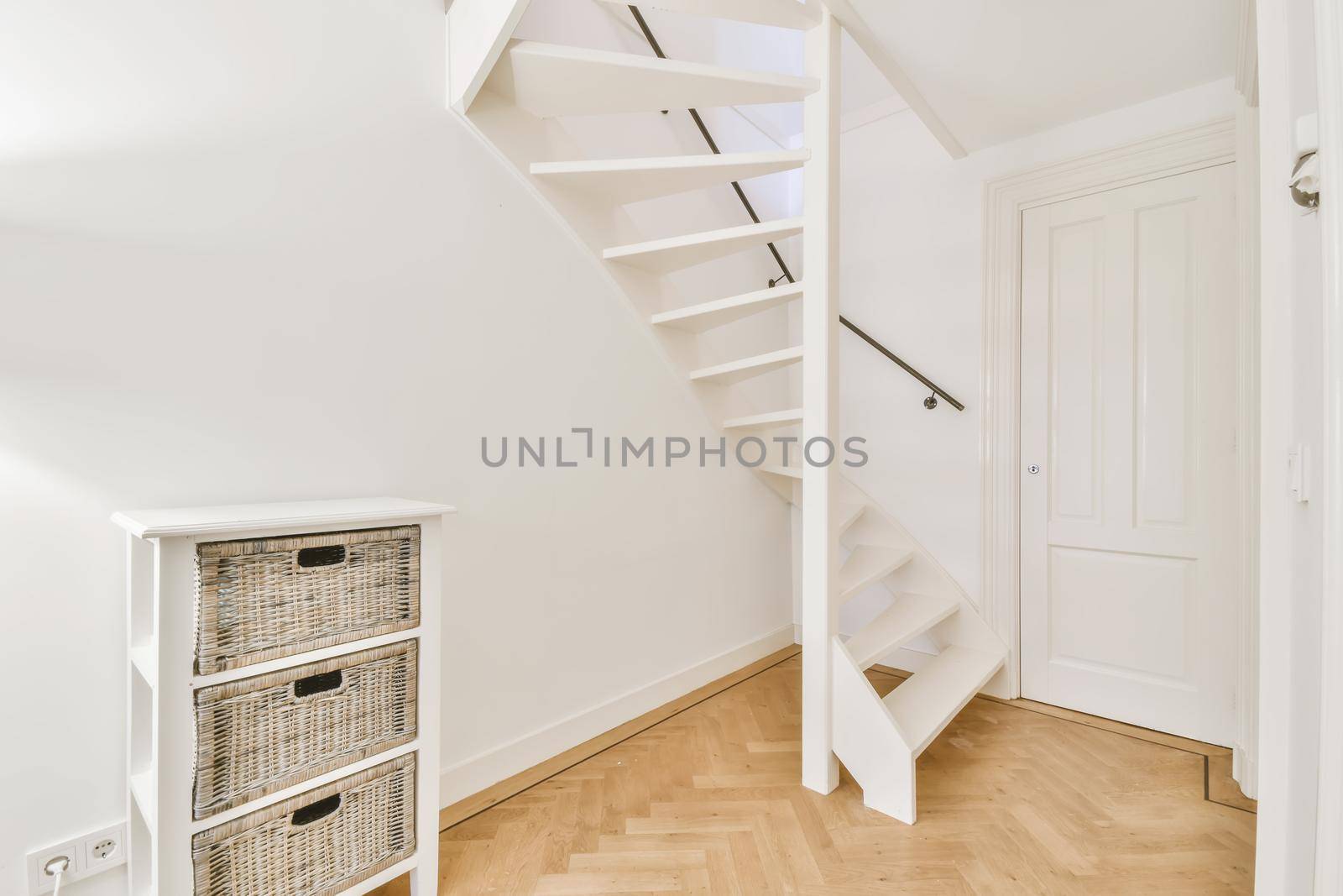 White hallway with wooden stairway leading to second floor of modern luxury apartment with minimalist interior design
