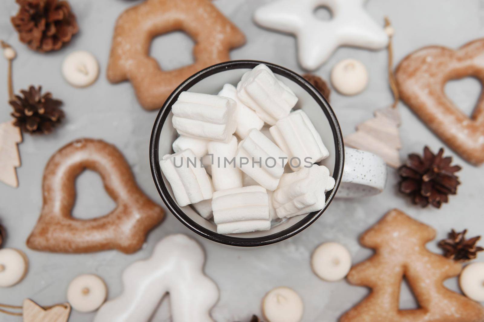 A cup of cocoa with marshmallows and Christmas gingerbread on the table. The concept of desserts and drinks during the Christmas holidays.