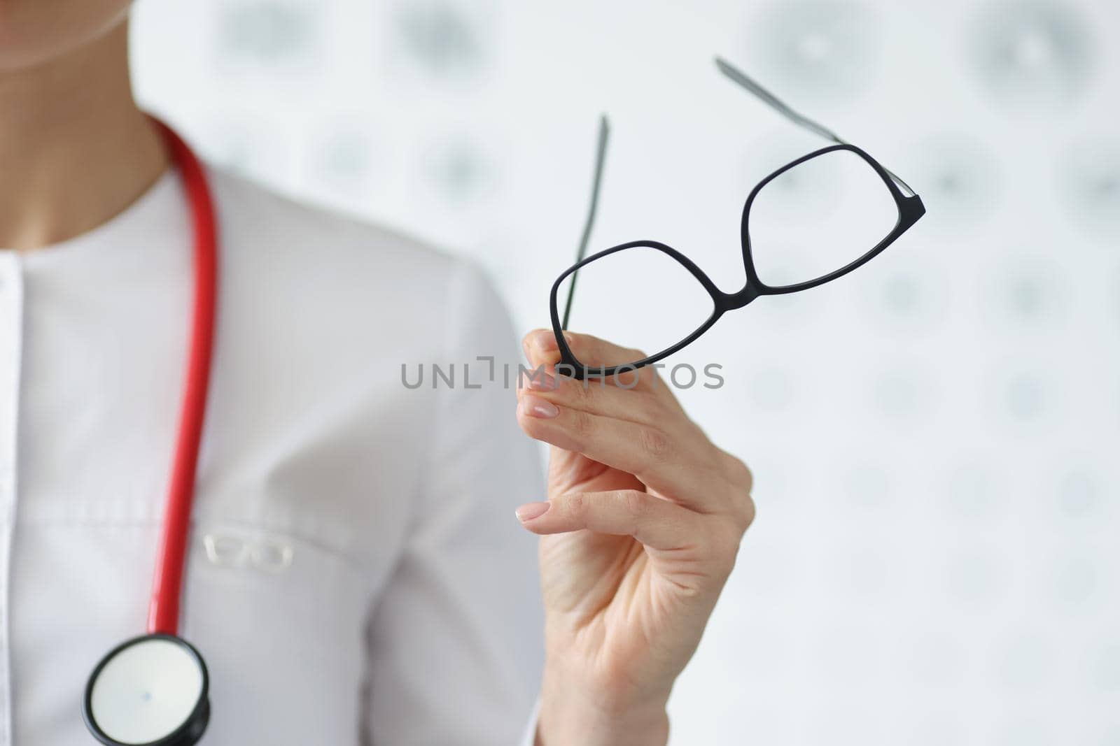 Close-up of professional doctor ophthalmologist hold glasses in black frame. Qualified eye doctor invite on appointment. Vision, medicine, checkup concept