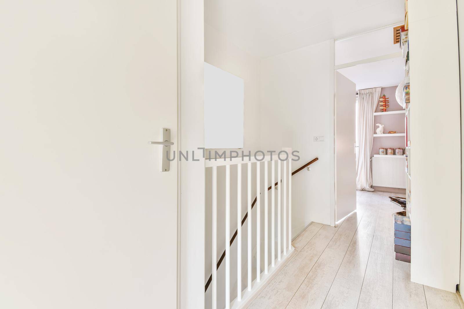 Closed white room door next to the top of the stairs of the house