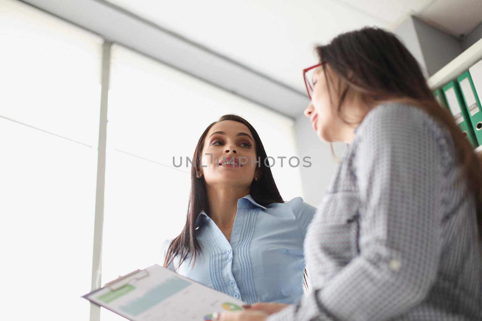 Portrait of female coworkers discussing report business growth and statistics. Colleagues in company office create strategy. Business, job, career concept